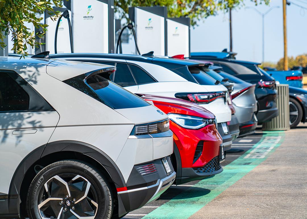 A row of different electric vehicles getting recharged at a station.