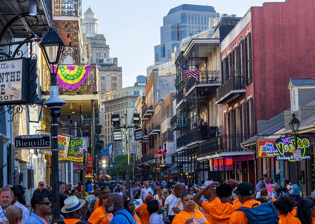 People walking down French Quarter where restaurants and bars are along Bourbon Street in New Orleans.