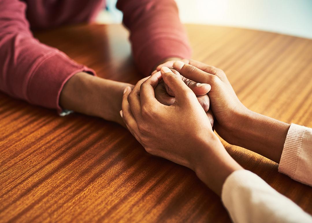 A couple holding hands with care and support.