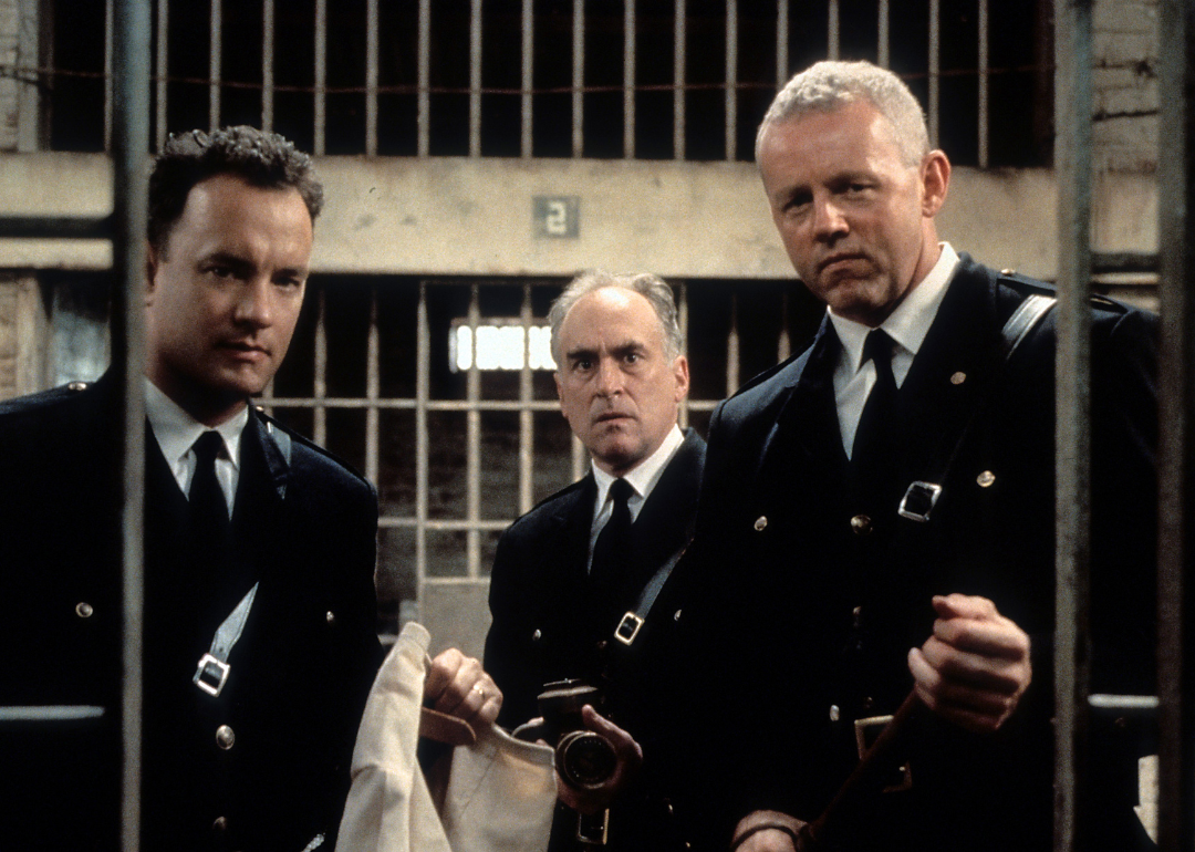 Tom Hanks (left) and David Morse (right) stands outside of a jail cell with two guards in a scene from the film 'The Green Mile', 1999. 