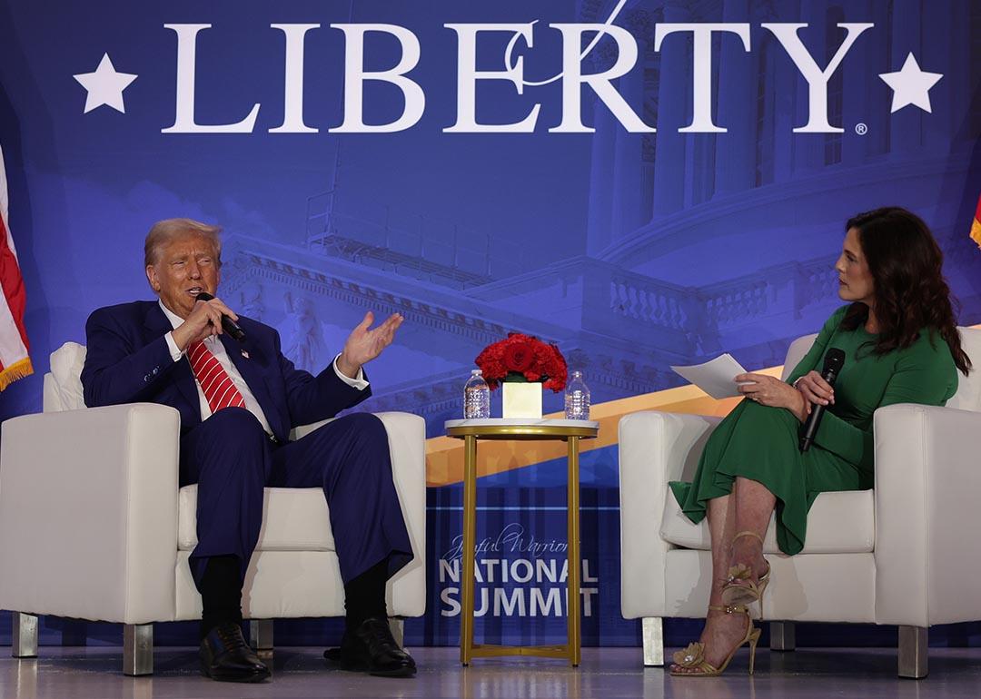 On stage, Donald Trump speaks as Co-founder of Moms for Liberty Tiffany Justice looks on during the 2024 Joyful Warriors National Summit on August 30, 2024 in Washington, DC.