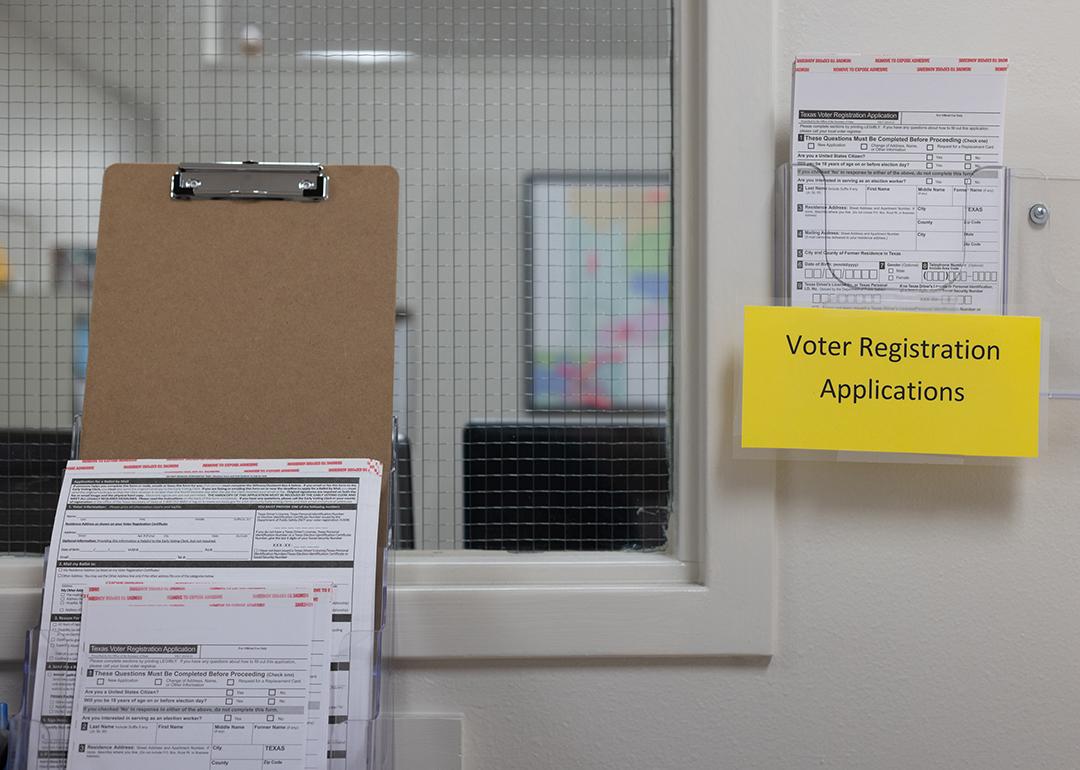 Voter registration applications hang in a rack at a Texas county elections office in 2024.