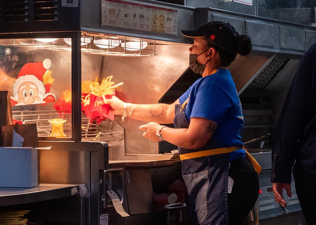 View of the back of a McDonalds worker at fry station.