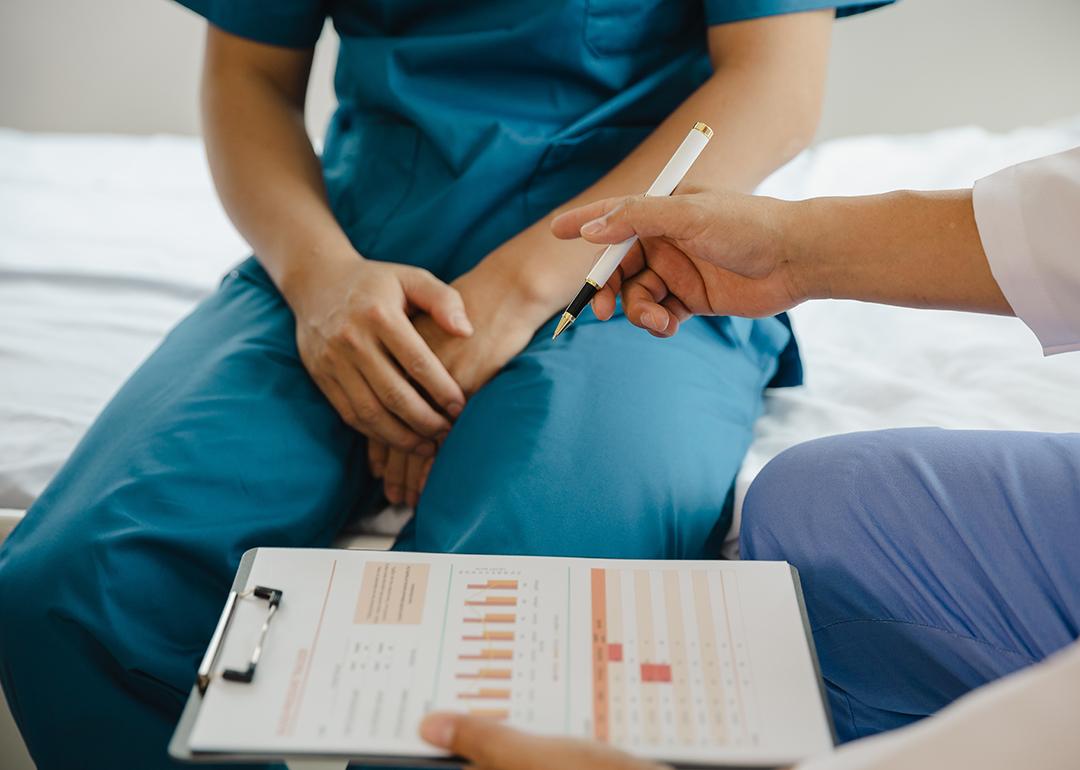 Male patient holding his crotch consults with a doctor.