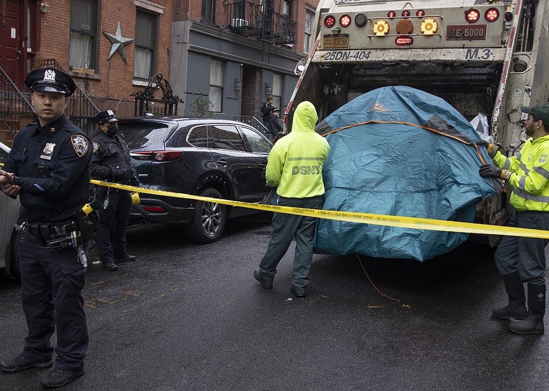 Police enforce a sweep of a homeless encampment, throwing tents and other possessions of the homeless in a trash truck in the East Village neighborhood of New York City.