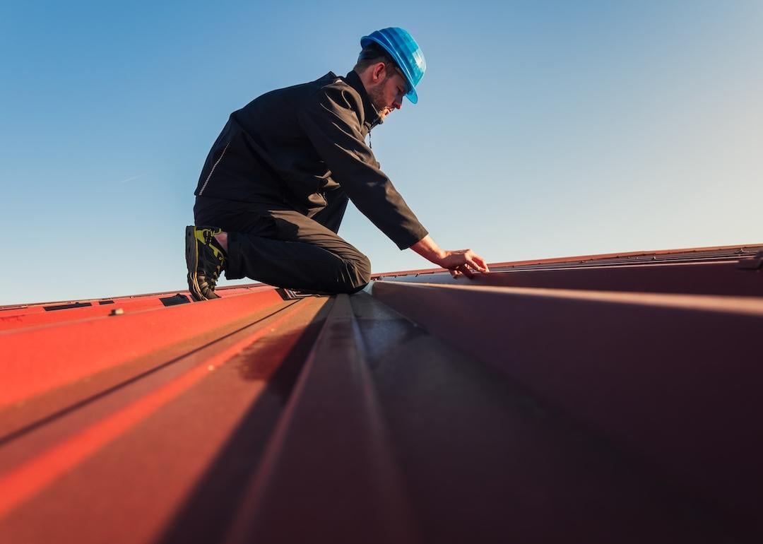 Construction worker in a helmet installing a roof.