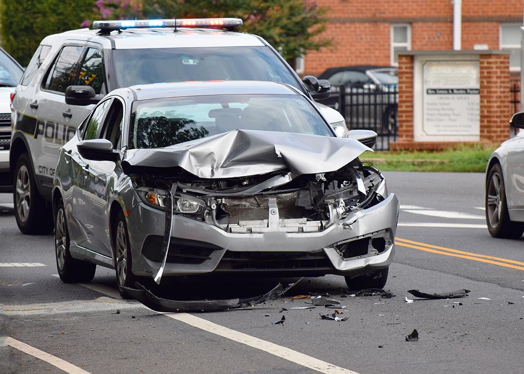 A car is smashed due to accident with police in the background in Alexandria, VA.