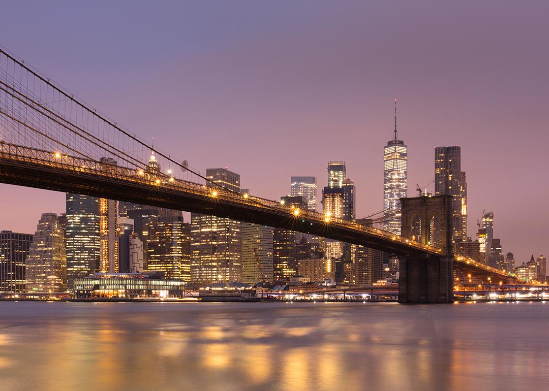 Brooklyn Bridge and Lower Manhattan skyline at dawn in New York City.