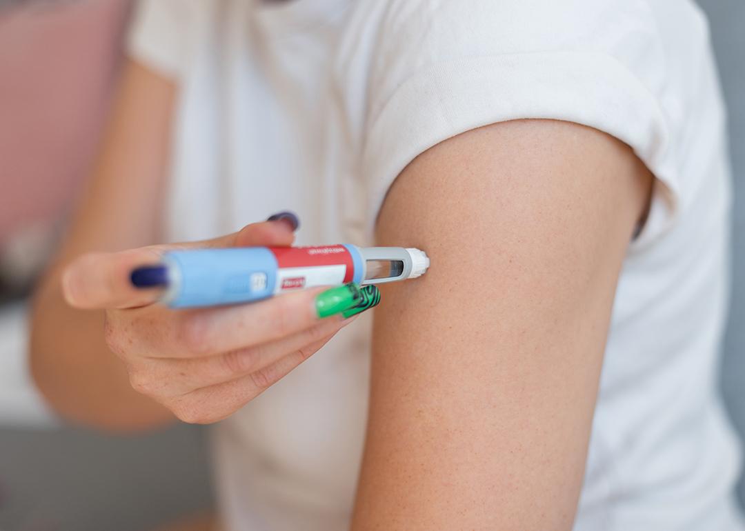 Person using a weight loss injectable on arm at home.