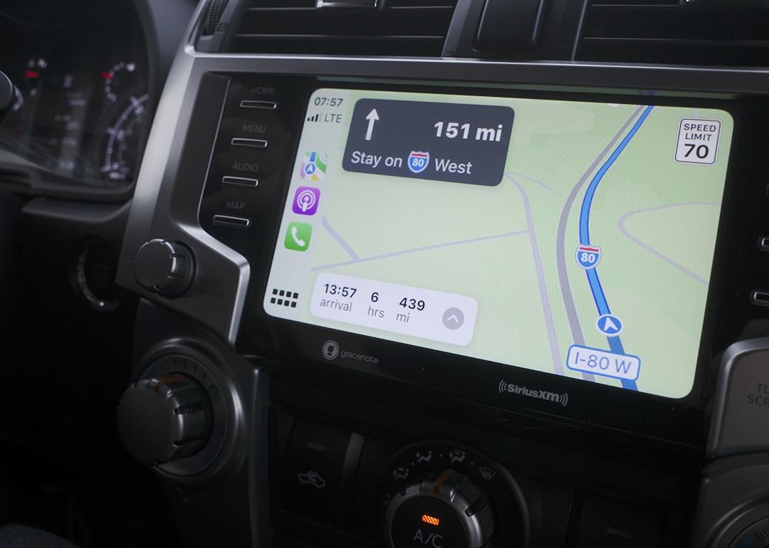 A car navigation system showing map directions to a destination.