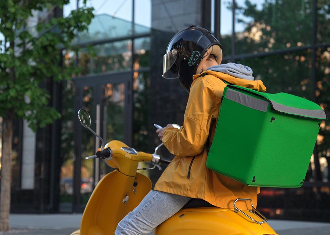 A food delivery rider looking at tasks on phone.