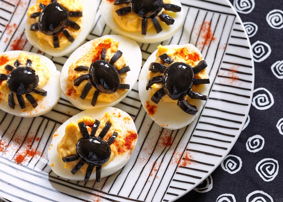 Deviled eggs with spiders made of olives for Halloween.