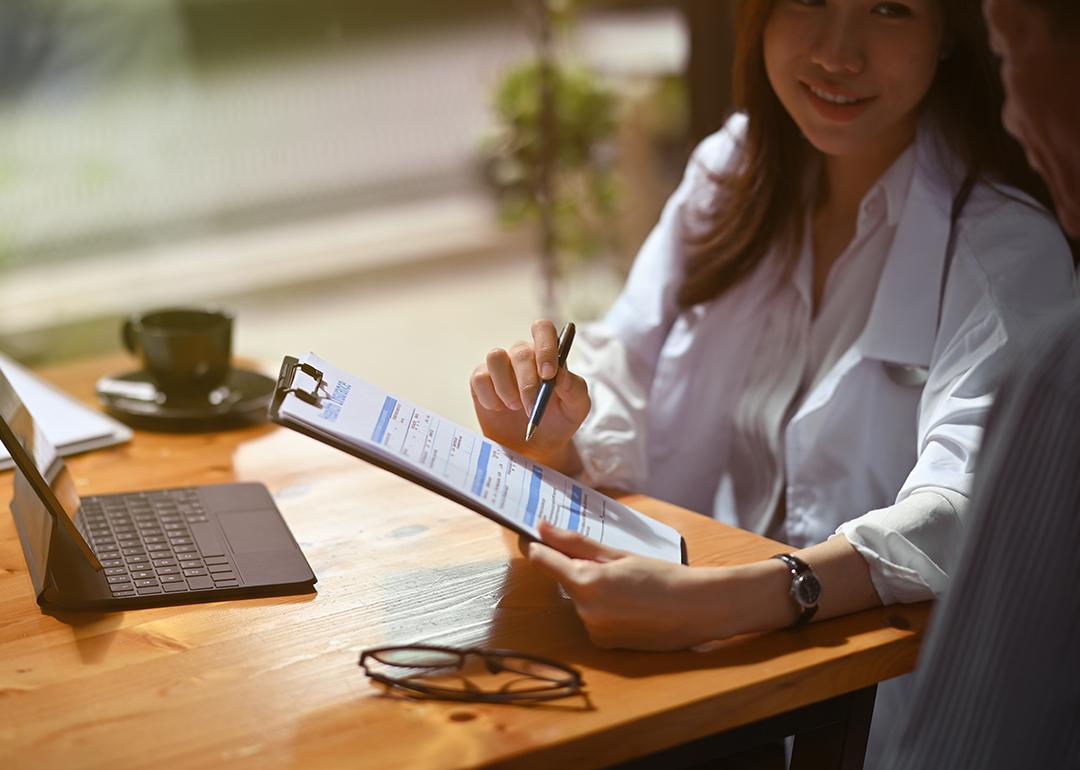 Female healthcare professional guiding patient in filling up insurance forms.