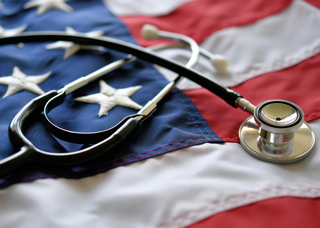 Conceptual image of American healthcare where a stethoscope is on top of a U.S. flag.