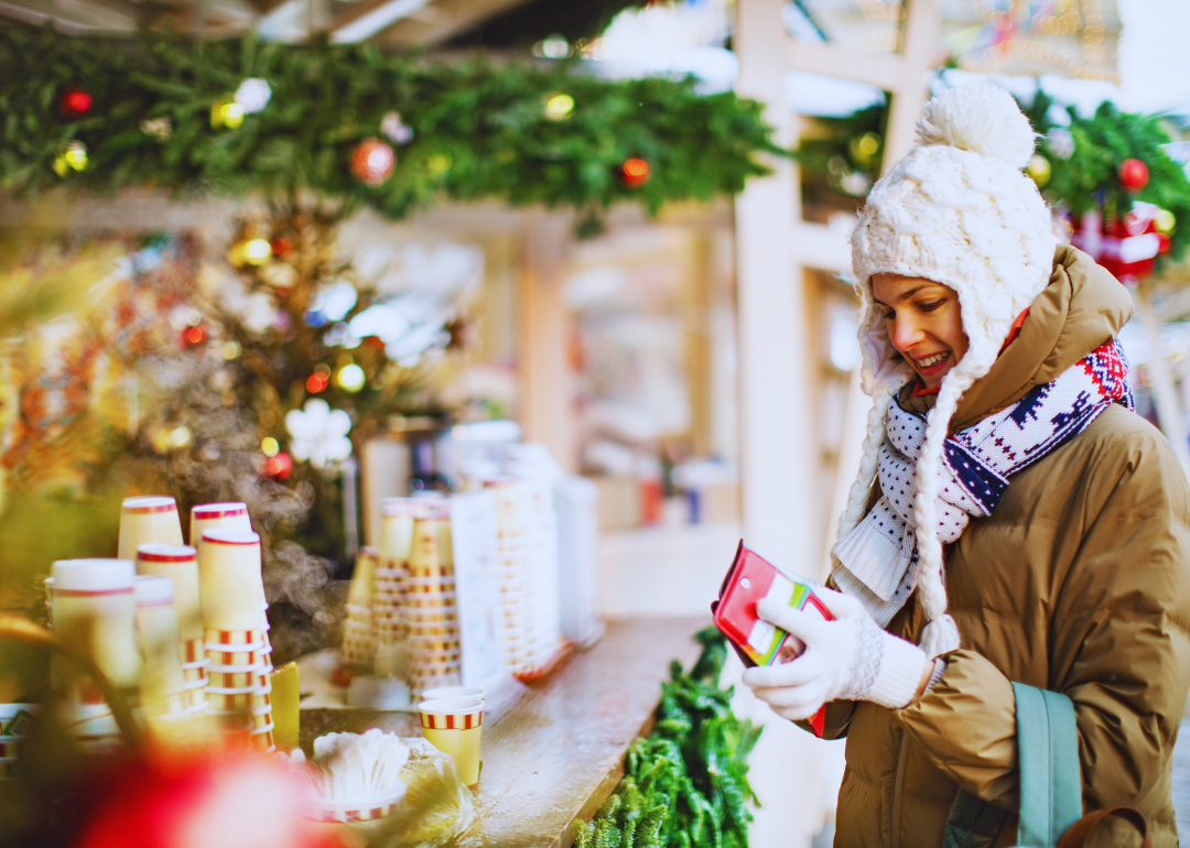 Woman buys coffee from outdoor kiosk in winter