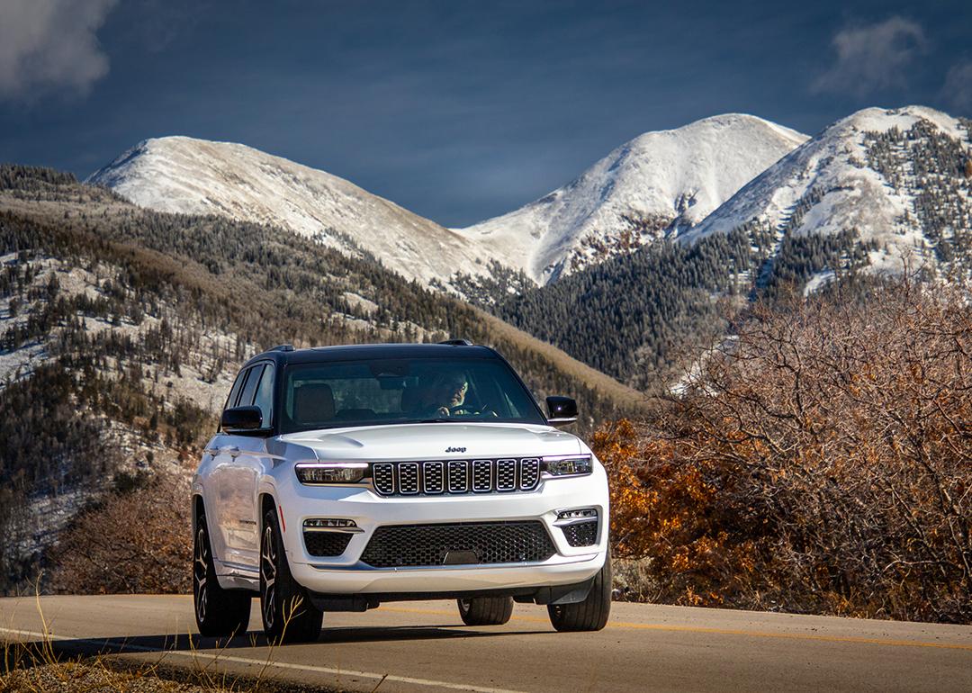 A white 2025 Jeep Grand Cherokee Summit Reserve SUV on the road.