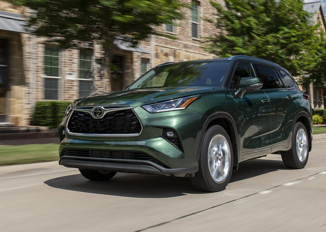 A green 2025 model of the Toyota Highlander on the road.