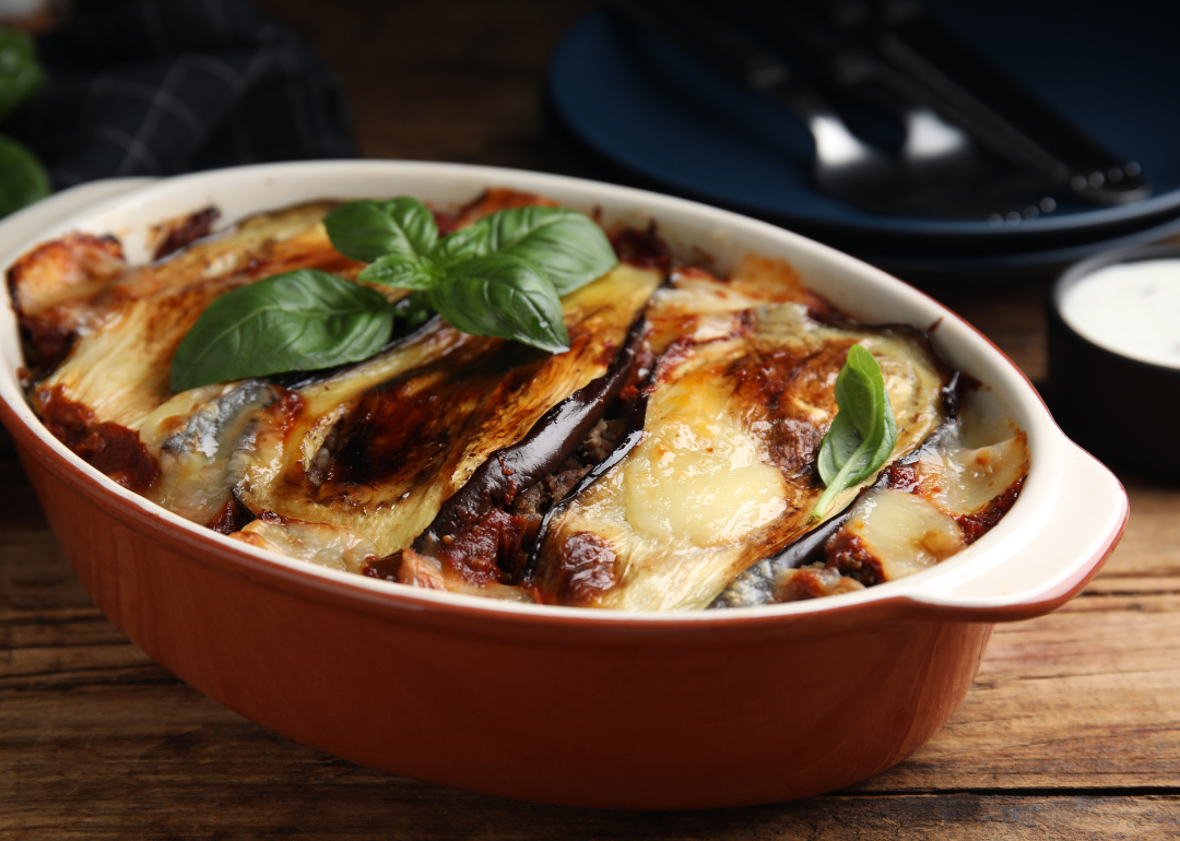 Freshly-baked eggplant lasagne in a red baking dish