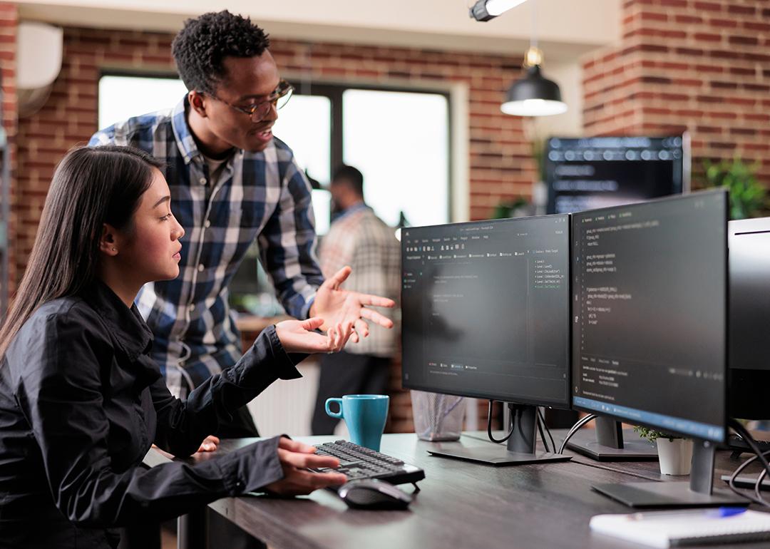 Two members of a cybersecurity team configuring data issues.