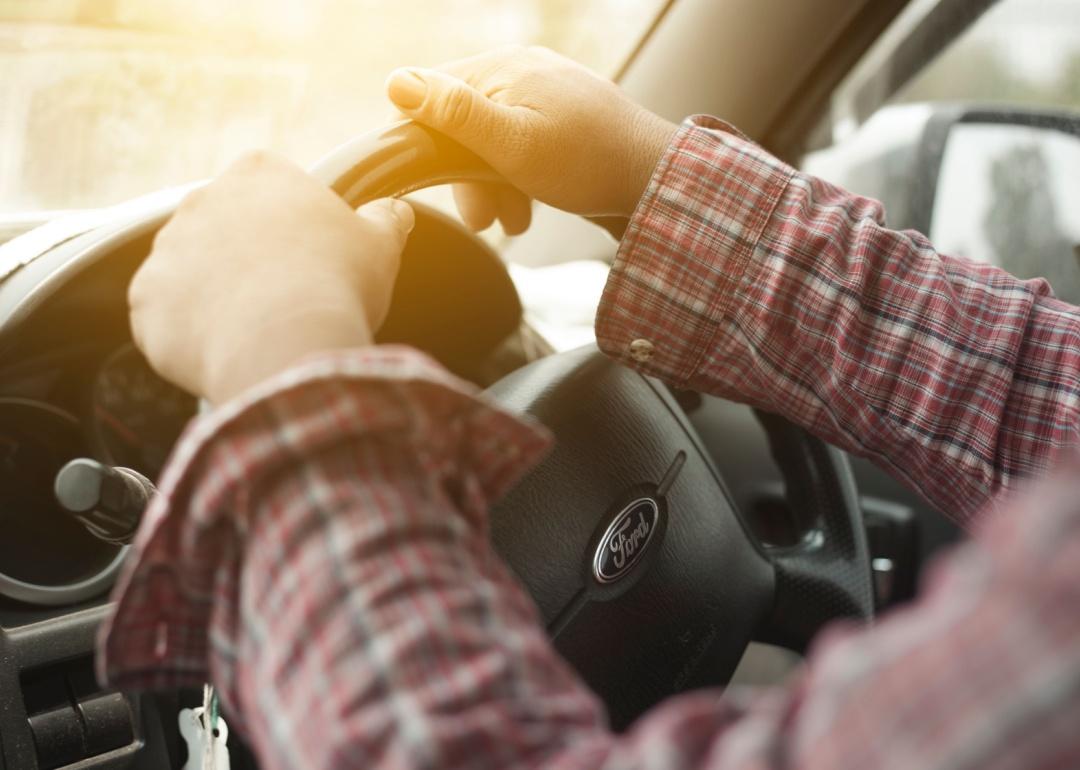 Close-up of a person's hands on a Ford steering wheel.