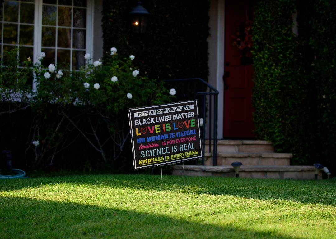 A lawn sign with the words 'Black lives matter. Love is love. No human is illegal. Science is real. Kindness is everything."