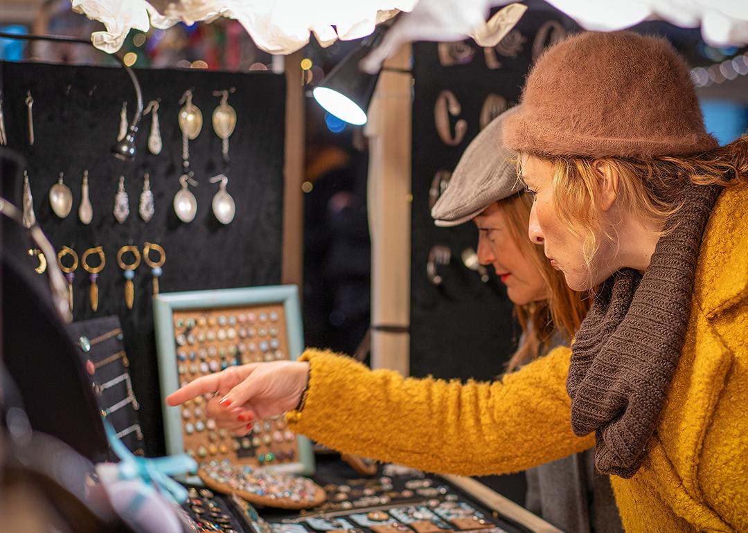 Two women shopping for jewelry at a Christmas market