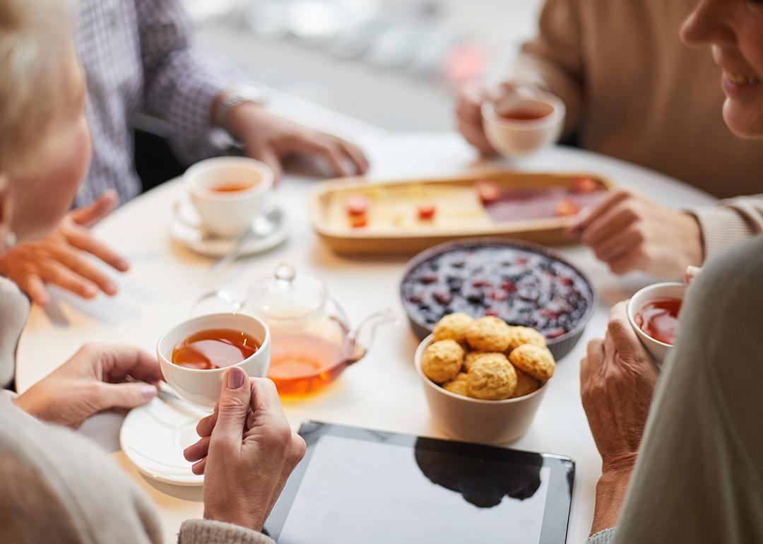 Seniors drinking tea together at a table.