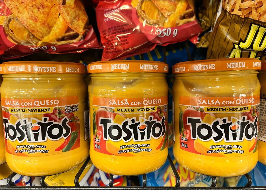 Jars of Tostitos Salsa Con Queso on a supermarket shelf