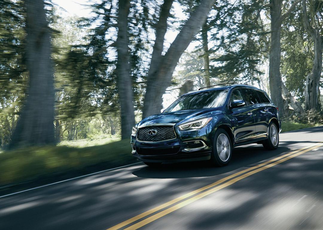 Blue 2020 INFINITI QX60 driving on the road.