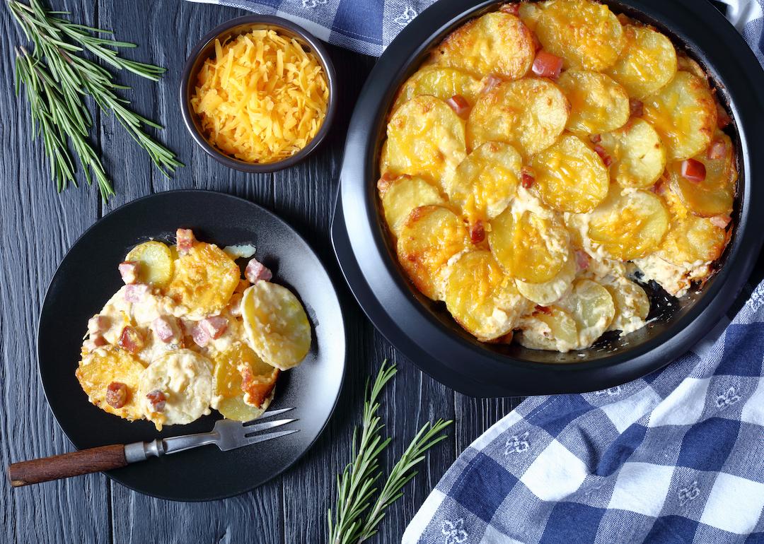 Gratin potatoes in a baking dish and on a plate on a Christmas table.