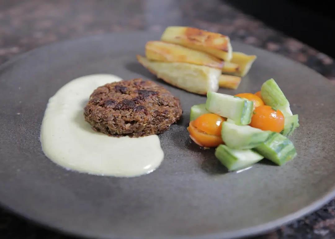  sautéed patty made of soy pulp inoculated with Neurospora intermedia fermented by Hill-Maini. The patty is joined by a cashew cream sauce, baked yams, and a tomato and cucumber salad.