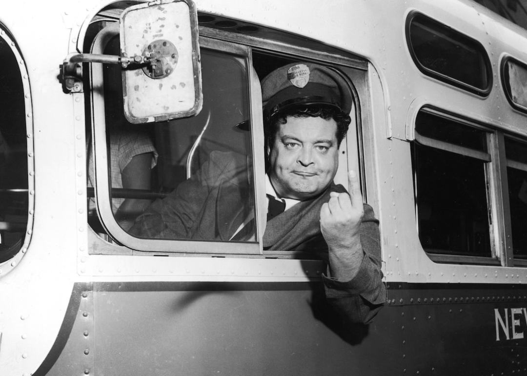 Actor Jackie Gleason as Ralph Kramden posing on his bus in a still from the 1950s television series 'The Honeymooners.'