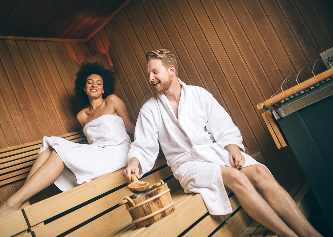 Young happy couple relaxing inside a sauna at a luxury hotel spa.