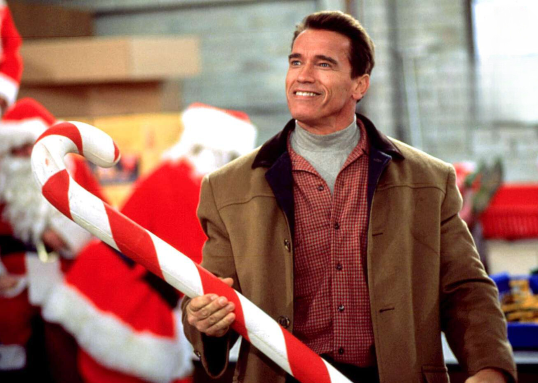 Arnold Schwarzenegger holding a giant candy cane in a scene from the movie 'Jingle All The Way'