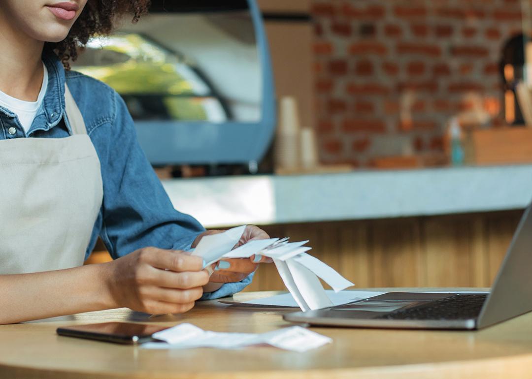 A female small business owner looking through receipts for tax filing.