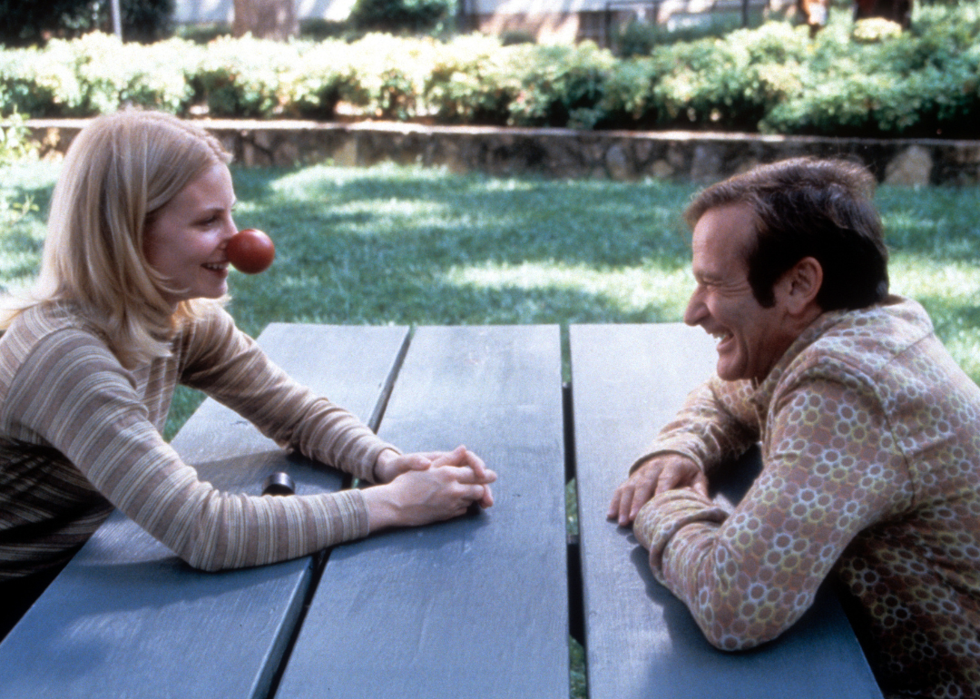 Monica Potter sits with Robin Williams in a scene from the film 'Patch Adams', 1998.