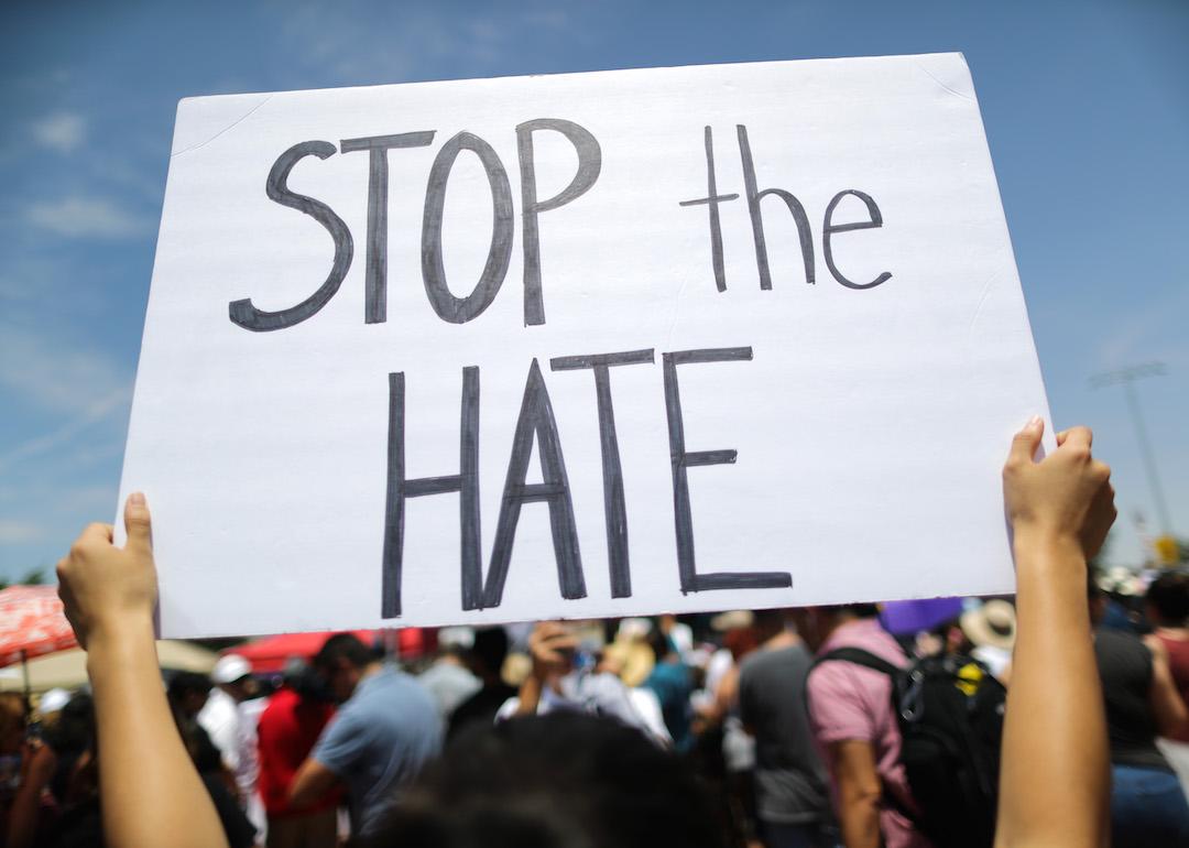 A demonstrator holds a sign reading 'Stop the Hate' at a protest.