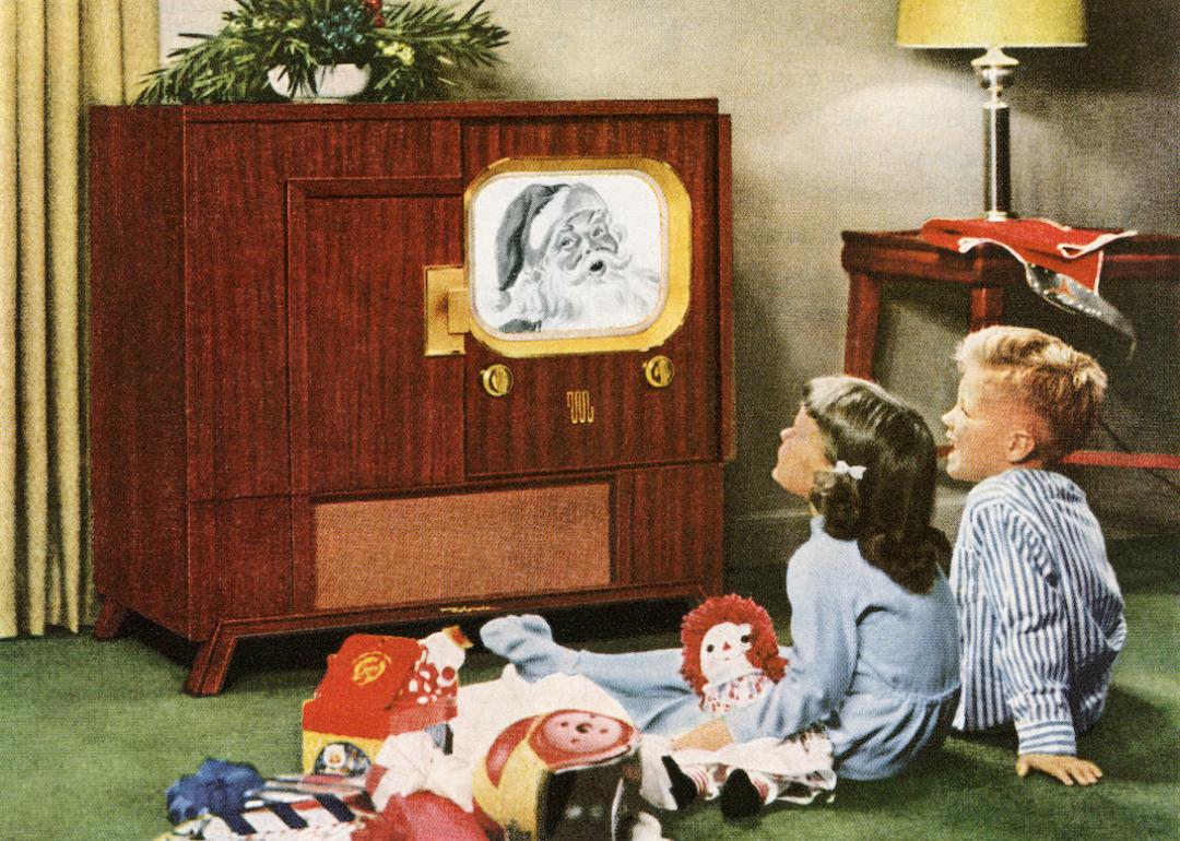 Children happily watching Santa Claus on television on Christmas circa 1950.