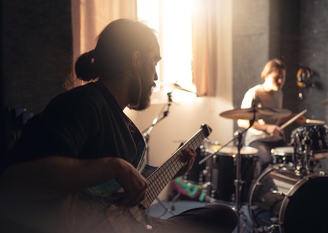 Band members such as a guitarist and drummer during a rehearsal.