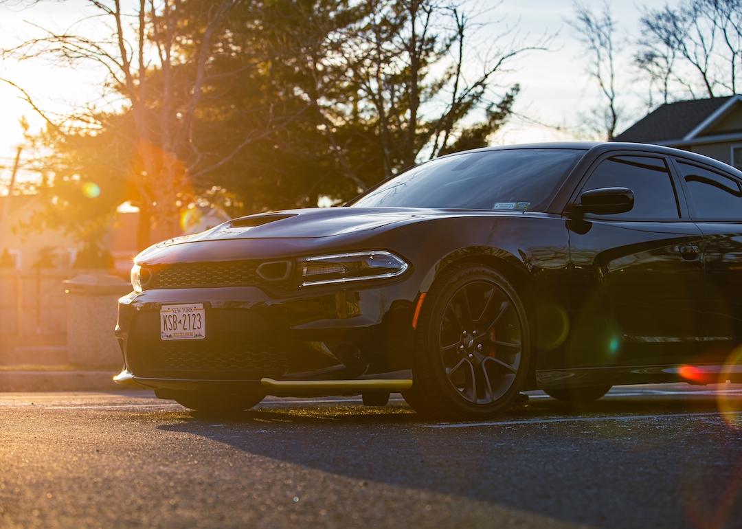 A black Dodge Charger HEMI with tinted windows in the parking lot.