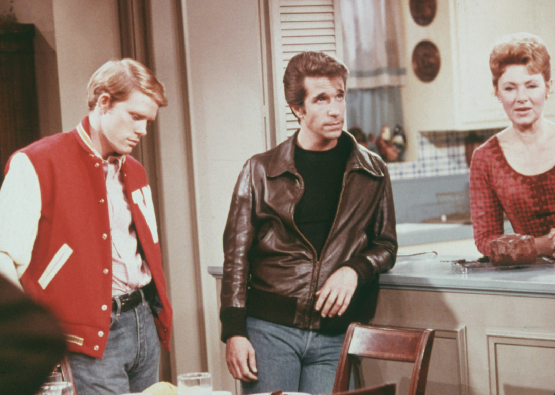 American actors Henry Winkler, as Arthur 'Fonzie' Fonzarelli, Ron Howard as Richie Cunningham, and Marion Ross as Marion Cunningham, in a scene from the television sitcom 'Happy Days', circa 1975.