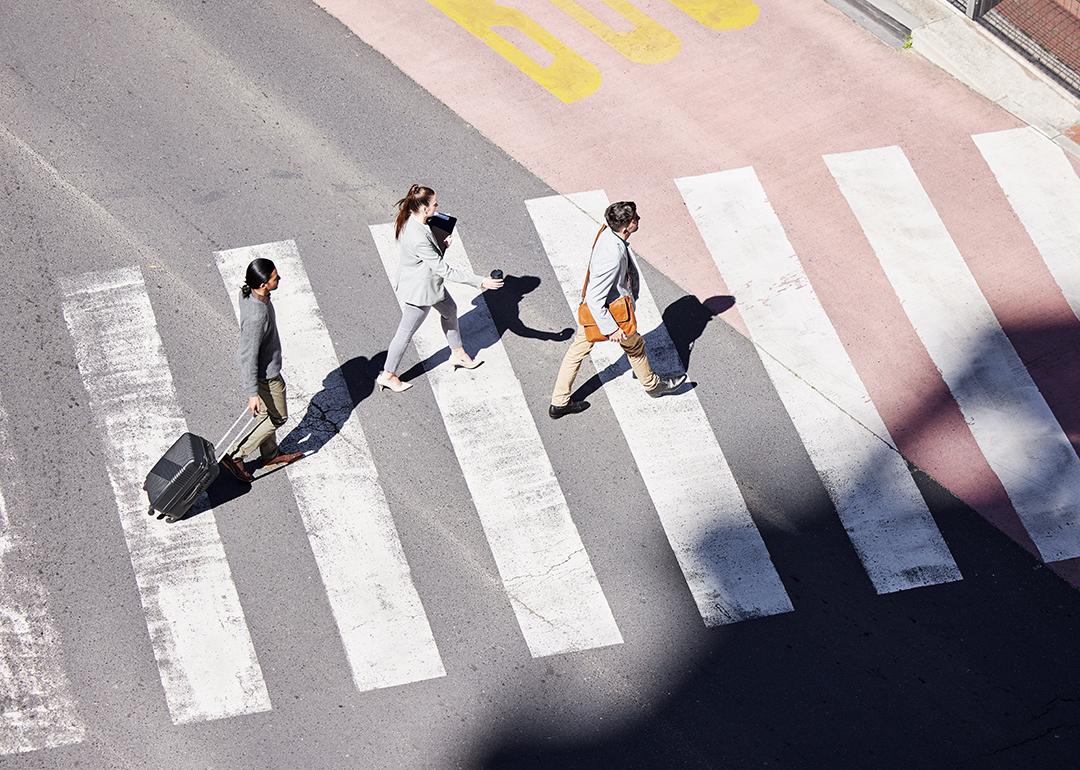 Traveling corporate professionals crossing a street. 