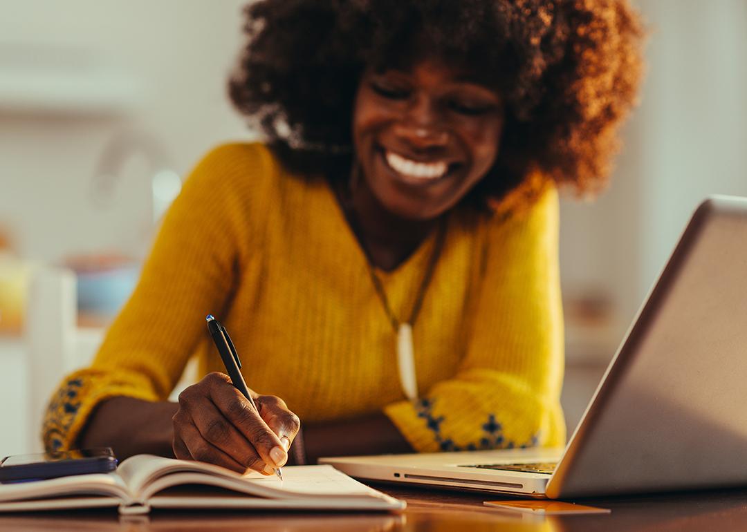 A woman exercising selective focus and taking notes in an agenda.