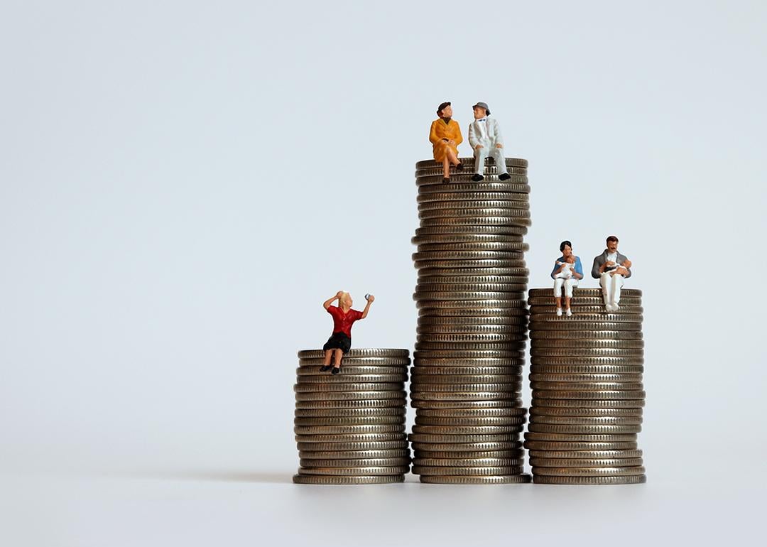 Small figures representing humans and different points in life on top of coins representing their typical amount of income and savings.