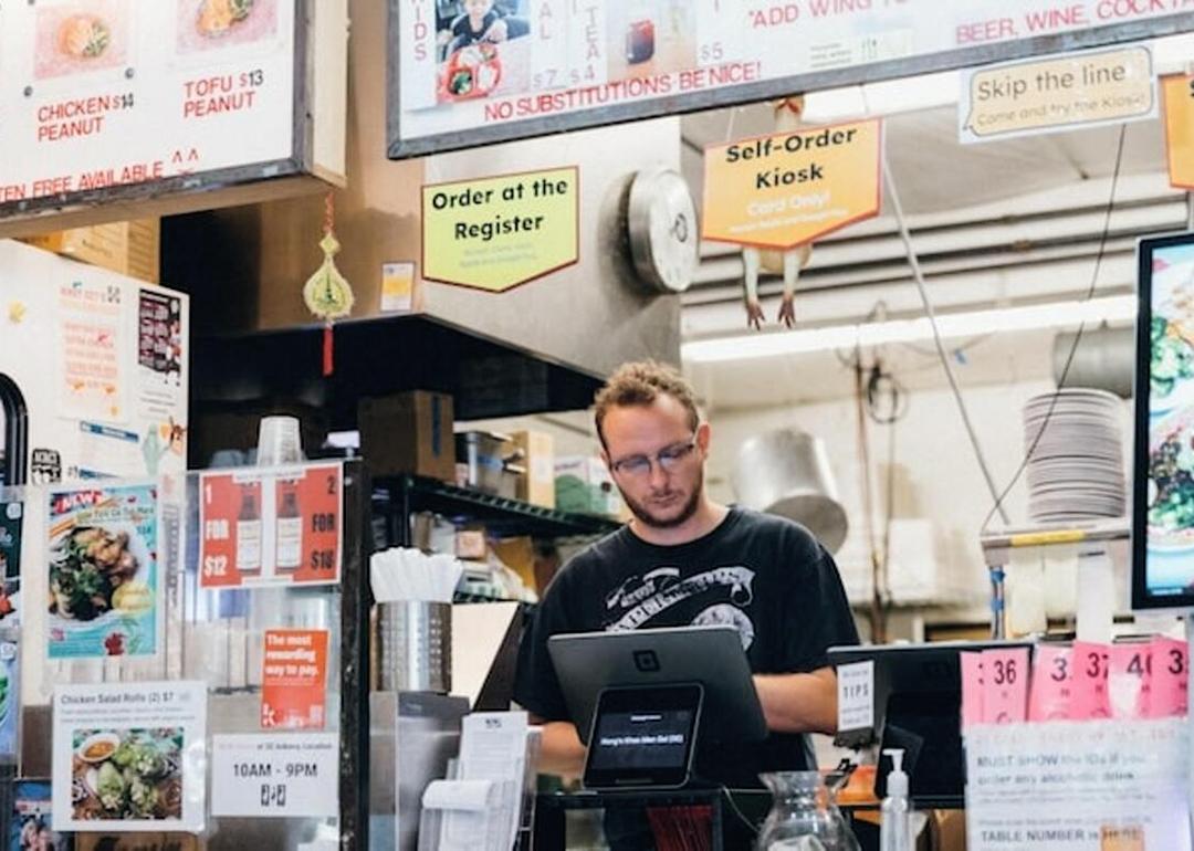 A restaurant owner manning the cash register.