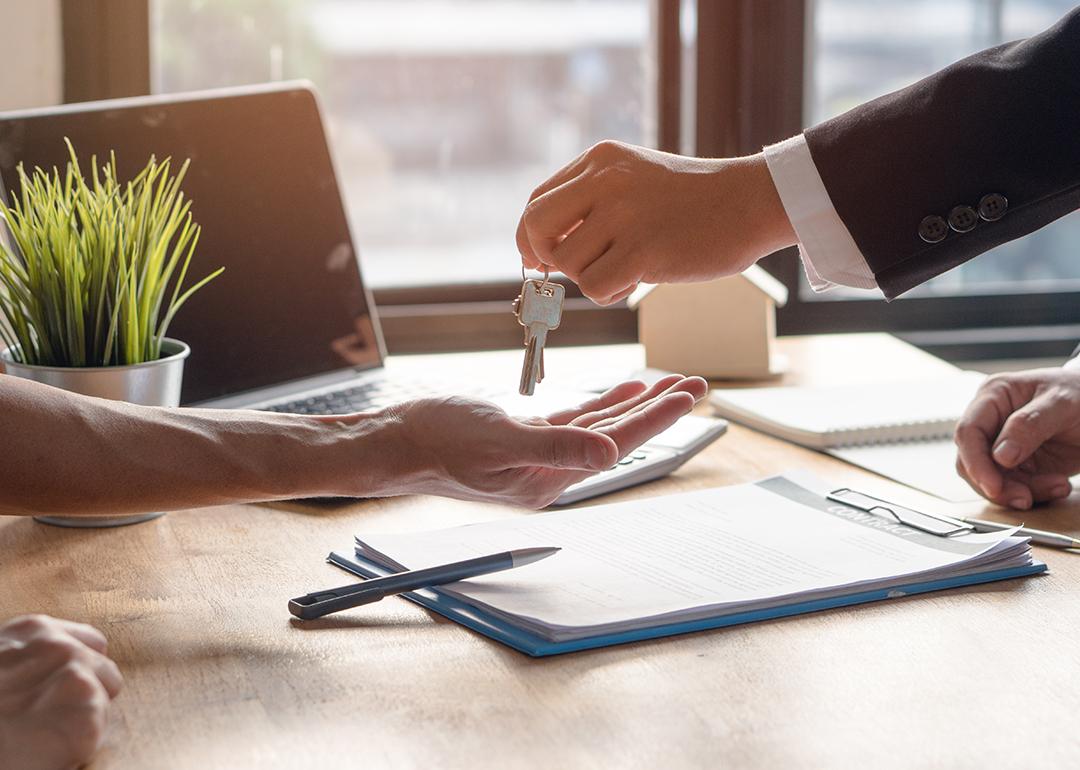 A landlord hands over keys of property to approved tenant.