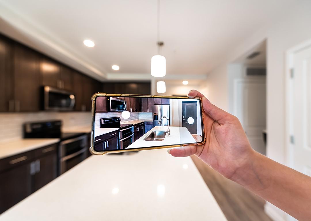 An apartment owner taking a photo of the interior of their property for marketing.