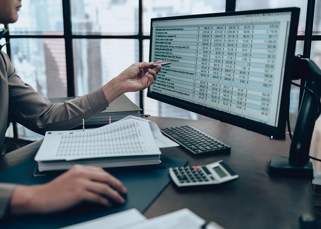 Finance person checking accounting data in an office computer.