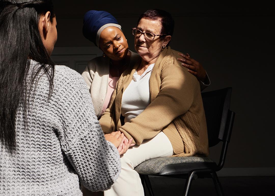 A senior woman in group support session with other women.