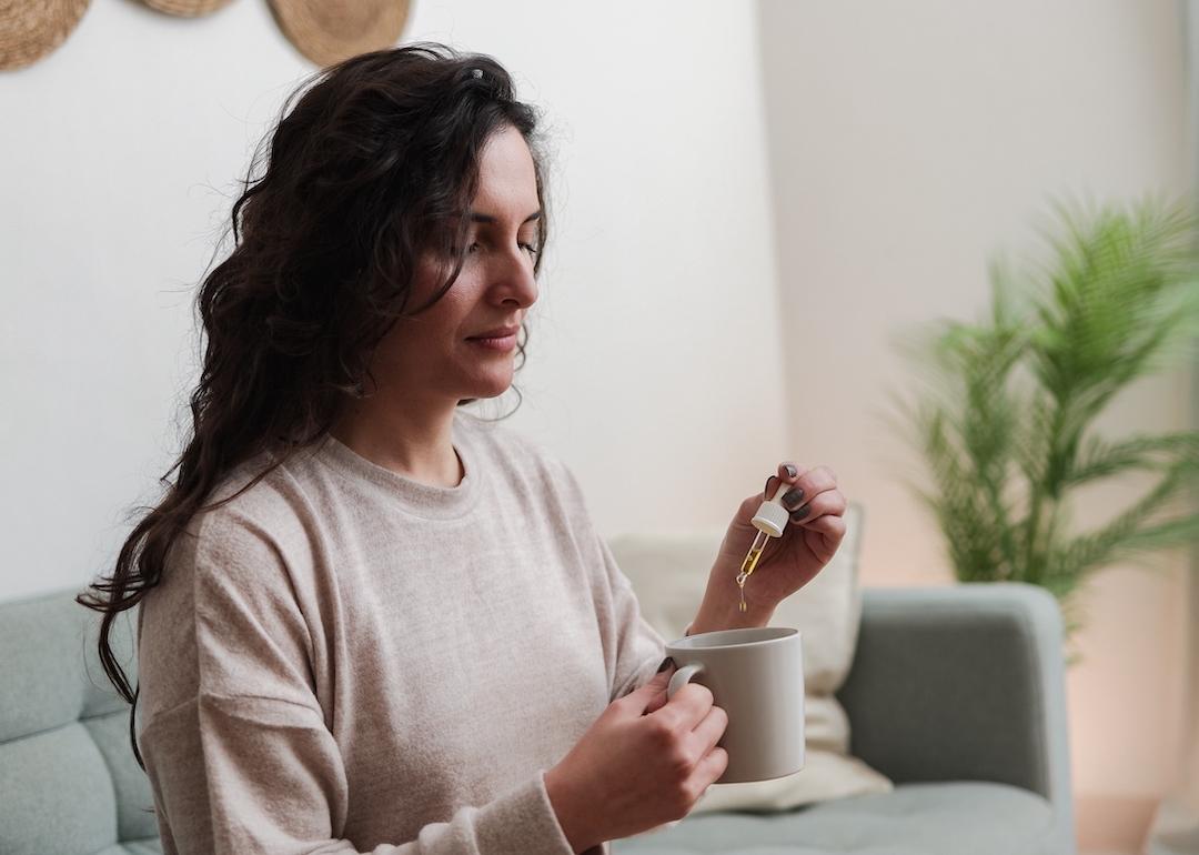 Woman holding pipette of medical cannabis oil.